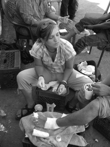 No More Deaths volunteer Maryada Vallet treats the injuries of a deported migrant at the NMD tent in Nogales, Sonora in 2007. Photo by Steve Johnston.